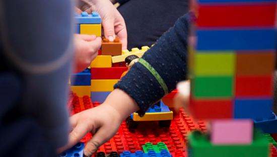 Barnehender som bygger lego