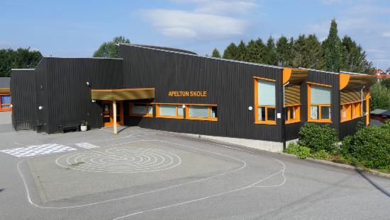 Brun skolebygning med oransje detaljer